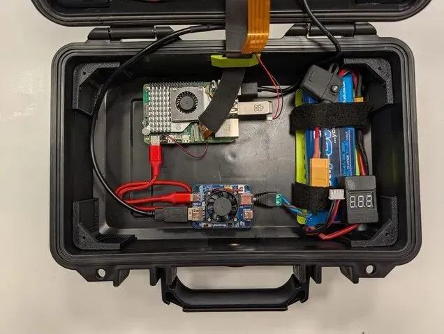 อุปกรณ์ภายในกระเป๋า Raspberry Pi Cyberdeck แสดงบอร์ด Raspberry Pi แบตเตอรี่และส่วนประกอบระบบจ่ายไฟ